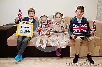 Four kids show inscription learn english. Foreign language learning concept Stock Photo