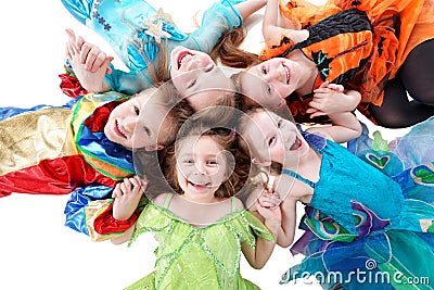 Four laughing girls and one boy, dressed in fancy dress, lie Stock Photo