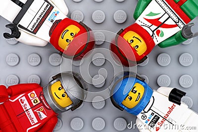 Four Lego driver minifigures on gray baseplate Editorial Stock Photo