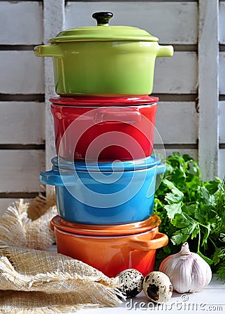 Four little colorful cooking pots, eggs and garlic Stock Photo