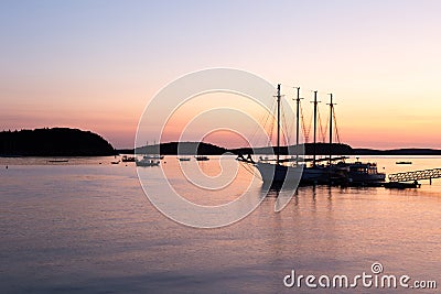 Four-mast sailboat and other smaller boats anchored in Frenchman Bay during a pink and orange sunrise Editorial Stock Photo