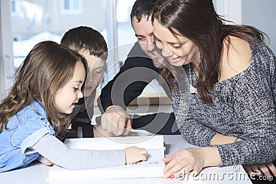 Four member of happy family read story book Stock Photo