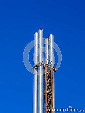 Four metal pipes against a blue sky Stock Photo