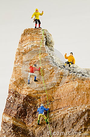 Miniature climbers climbing rocks Stock Photo