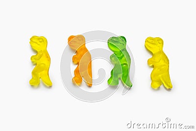 Four multi-colored dinosaur shaped gummy candies on a white background Stock Photo