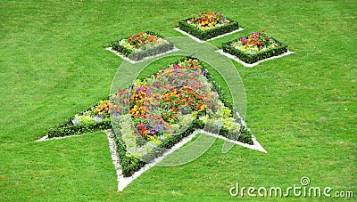 Multi colored flowerbeds in special shapes with surrounding lawn Stock Photo