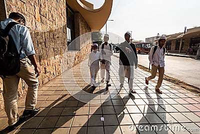 Four muslim boys walking on a sidewalk outside a Metro station in the city of Editorial Stock Photo