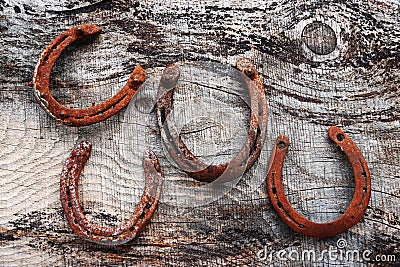 Four old rusty horseshoes on wooden ground Stock Photo