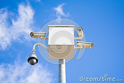 Four outside security cameras cover multiple angles on blue sky Stock Photo