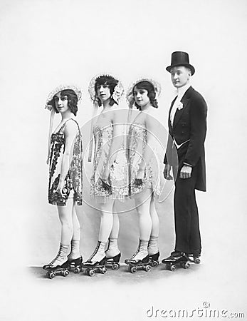 Four people on roller-skates standing in a line Stock Photo