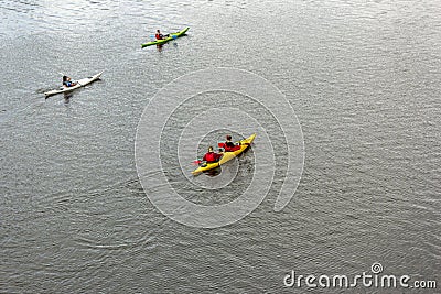 Four people on three kayaks are floating on a calm river. Several people are paddling a kayak. Kayaking on the river Editorial Stock Photo