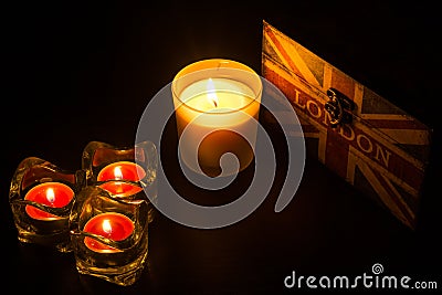 Four candles and a london box in a black frame Stock Photo