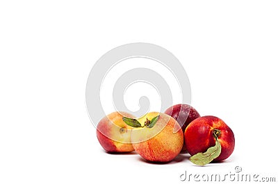 Four ripe yellow and red nectarines with green leaves isolated on a white background Stock Photo