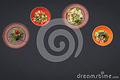 Four salads on a black background lie in a semicircle with sopy space Stock Photo