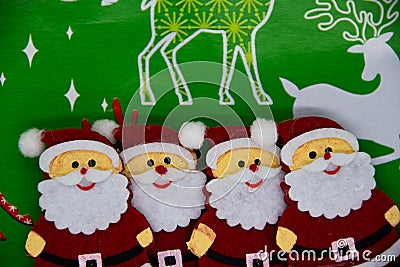 Four Santa Claus figures on a Christmas green background Stock Photo