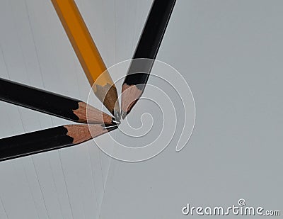 Four sharp pencils coming to a point on white printer paper Stock Photo