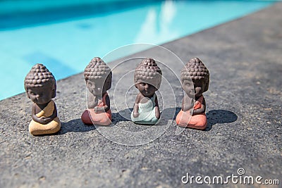 four small buddha statues in calm different rest pose. Stock Photo