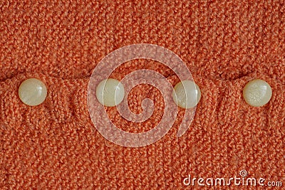 Four small gray plastic buttons on the orange woolen fabric Stock Photo