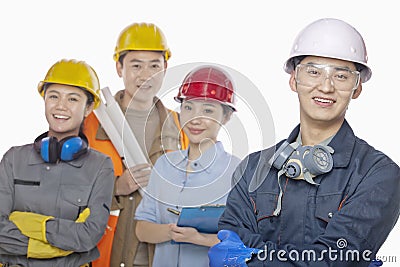 Four smiling construction workers against white background, focus in foreground, looking at camera Stock Photo