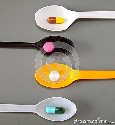 Four spoons with different pills Stock Photo