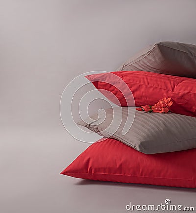 Four stacked cushions with red flower against the white background Stock Photo