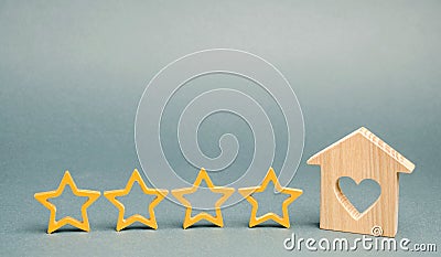 Four stars and a wooden house on a gray background. Success. Feedback. Good evaluation of the critic. Hotel rating. Quality of Stock Photo