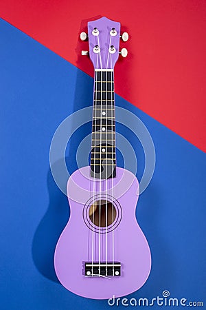 Four string ukulele guitar on blue-red background Stock Photo