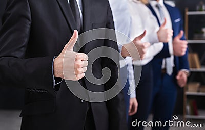 Four successful businessmen showing thumbs up in office Stock Photo