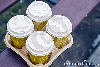 Four take-out coffee in holder. Take coffee to work for the entire office. Coffee time concept Stock Photo