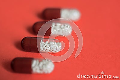 Four transparent capsule tablets with granules on a uniform background. Macro. Living coral. Shallow depth of field. Health and Stock Photo