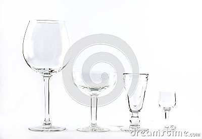 Four transparent elegant crystal glasses for cocktails lined next to each other on a white background Stock Photo