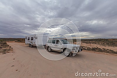 Four wheel drive vehicle and large caravan parked on an outback track. Stock Photo