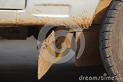 A four wheeler is parked and has dirt all around down the wheel and chassis. Indian motor with side door is very reliable Stock Photo