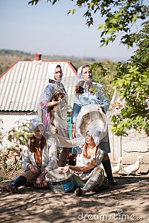 Four women are busy working in the yard. Retro style, countryside, farm Stock Photo