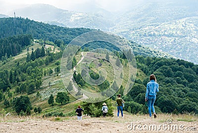 Four women come down the mountain. Tourists inspect the picturesque mountain landscape. Mountain trail along the ridge Editorial Stock Photo