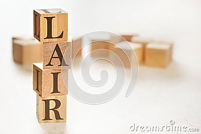 Four wooden cubes arranged in stack with text LAIR meaning Listen, Acknowledge, Identify, Reversal on them, space for text / Stock Photo