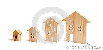 four wooden houses stand in ascending order on a white background. Isolate The concept of increasing population density Stock Photo