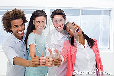Four workers giving thumbs up and smiling to camera Stock Photo