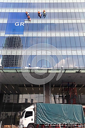 Four workers washing windows in the office building Stock Photo