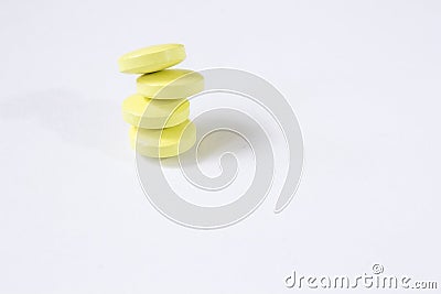 Four yellow tablets are stacked on top of each other. White background Stock Photo