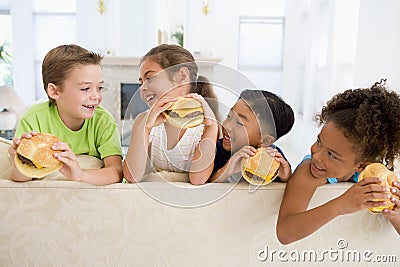 Four young children eating cheeseburgers Stock Photo