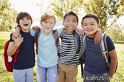 Four young smiling schoolboys hanging out on a school trip Stock Photo