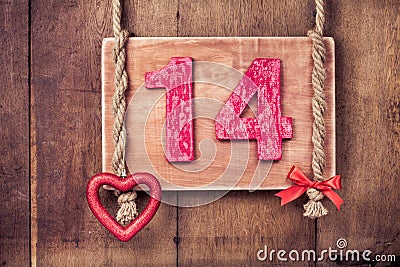 Fourteen valentine vintage card, heart hanging on wooden wall background Stock Photo