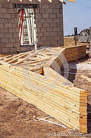 Fourteen wood trusses, stacked up, on ground Stock Photo