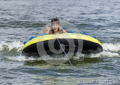 Fourteen year-old Amerasian boy tubing on Grand Lake in Oklahoma. Stock Photo