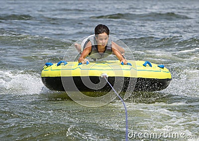 Fourteen year-old Amerasian boy tubing on Grand Lake in Oklahoma. Stock Photo