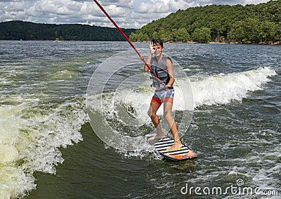 Fourteen year-old Amerasian boy wake surfing on Grand Lake in Oklahoma. Stock Photo