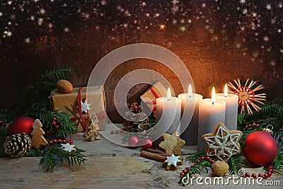 Fourth Advent, four candles are lighted, Christmas decoration and gifts on rustic wooden planks against a dark brown background Stock Photo