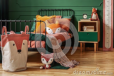 Fox theme in cute bedroom interior with green wall and orange bedding Stock Photo