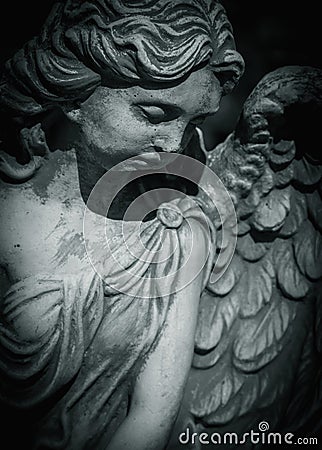 Fragment of an ancient statue of sad angel as a symbol of eternity, life and death. Religion concept Stock Photo